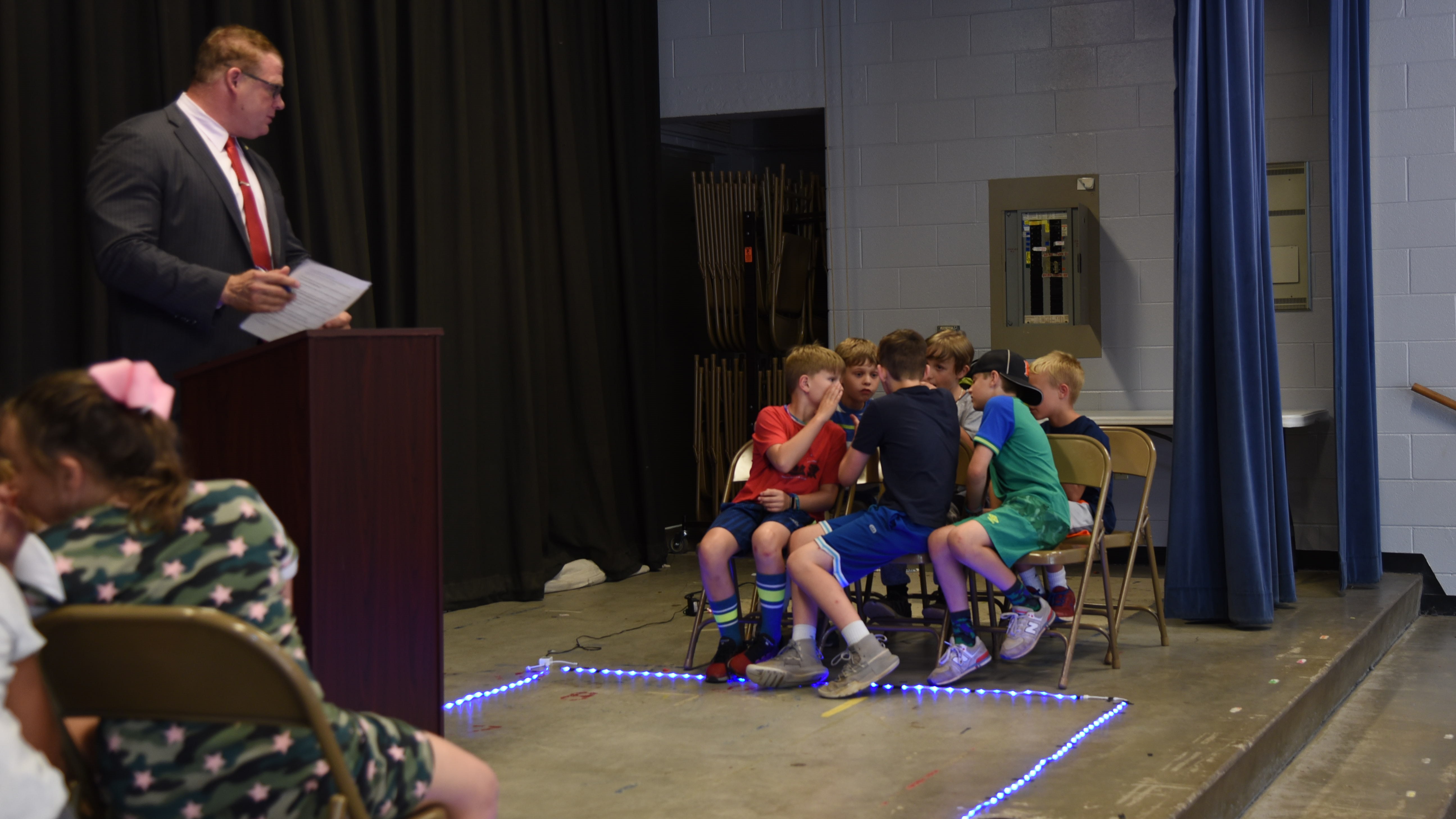 Contestants in a 'Book Battle' at Rocky Hill Elementary School discuss their answer as Knox County Mayor Glenn Jacobs, the game's host looks on. 